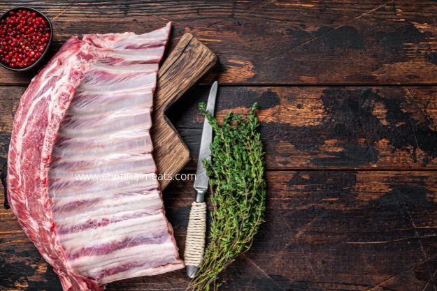 Buy Fresh Mutton Rib bones - Mutton Ribs Rack on Wooden Cutting Board.