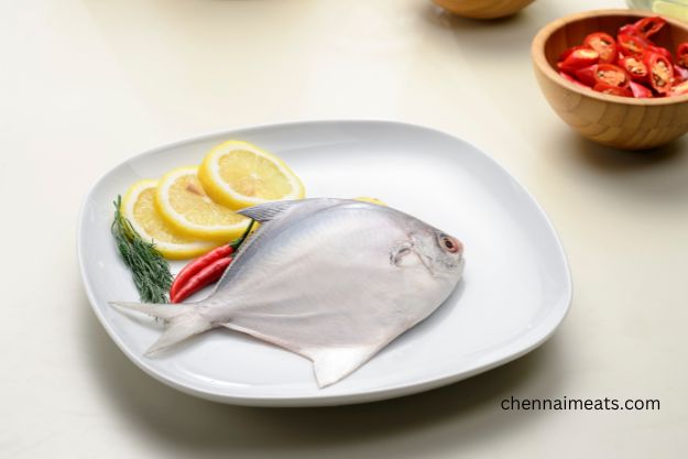 White Pomfret Vavval Meen decorated on white plate with lemon